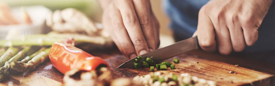 close-up of man chopping green onions